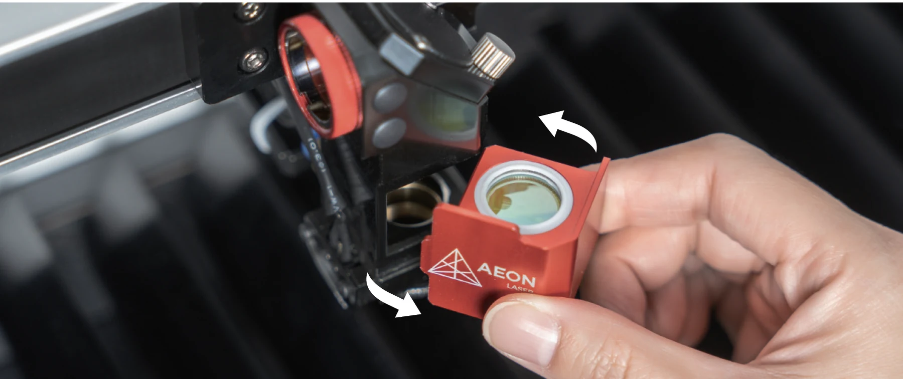 Magnetic AEON Mira S lens holder being removed from the laser head