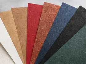 Fan of coated, textured and coloured specialty papers in kraft, red, blue, black and green