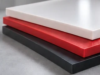 Rigid plastic sheets in white, red and black stacked on top of each other